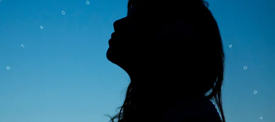 Silhouette of a person in front of blue background